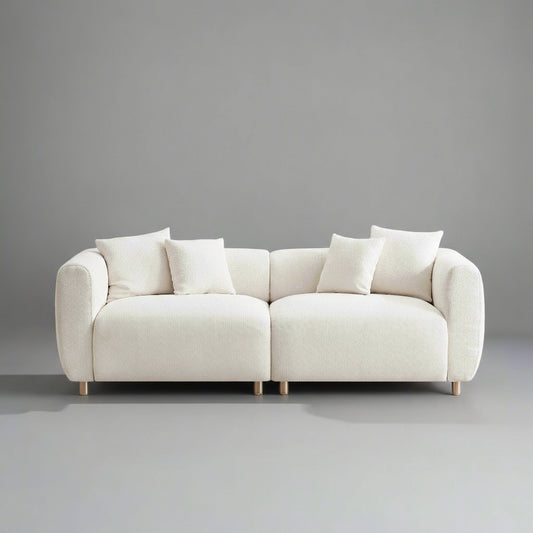 Beige sofa with white cushions on a gray background