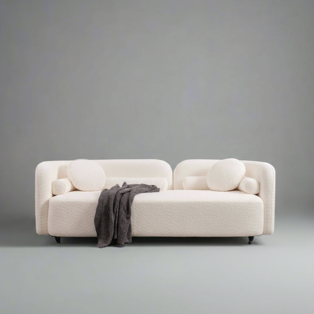 Modern living room with a white sofa, rocking chair, and decorative wall art.