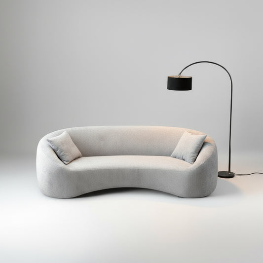 Modern gray sofa with a floor lamp against a plain wall