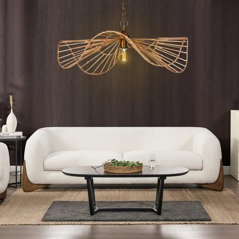 Modern living room with a white sofa, round coffee table, and decorative pendant light.