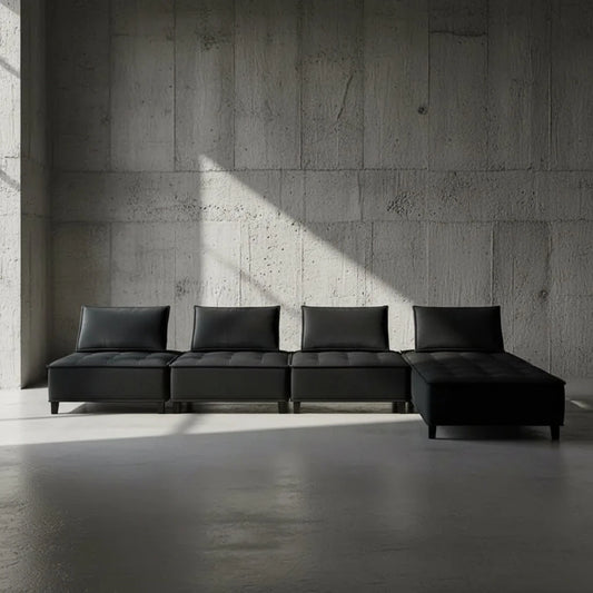 Black sectional sofa against a plain wall