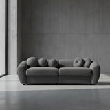 Gray sofa with unique circular backrests on a plain background