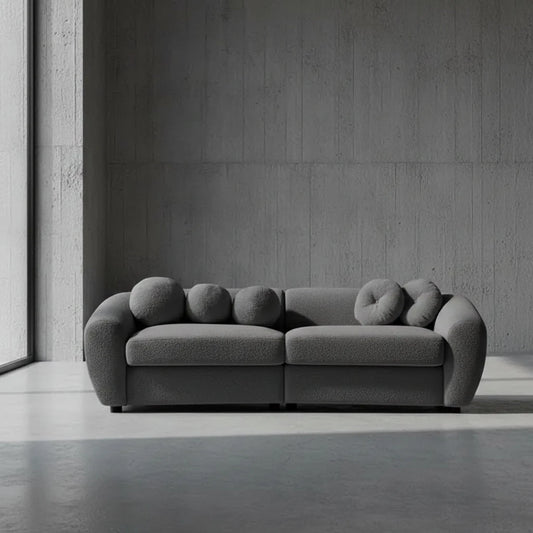 Gray sofa with unique circular backrests on a plain background