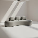 Gray sofa with three cushions on a plain background