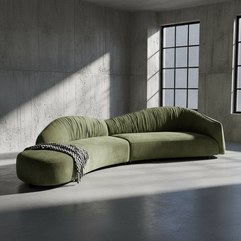 Green sectional sofa in a living room with a white wall and window.