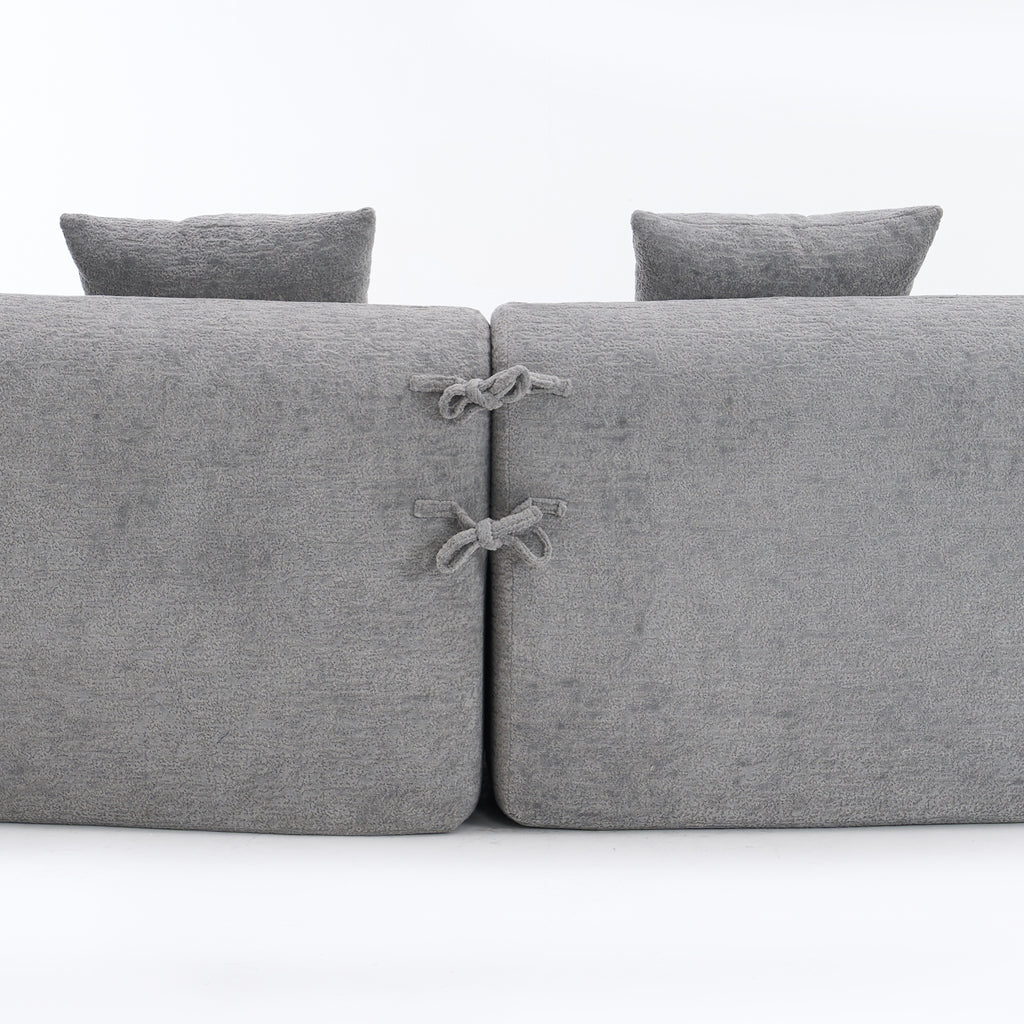 Close-up of the fabric connector ties on THE ORVILLE modular sectional, showing how the individual mist grey units securely attach to maintain the curved shape.