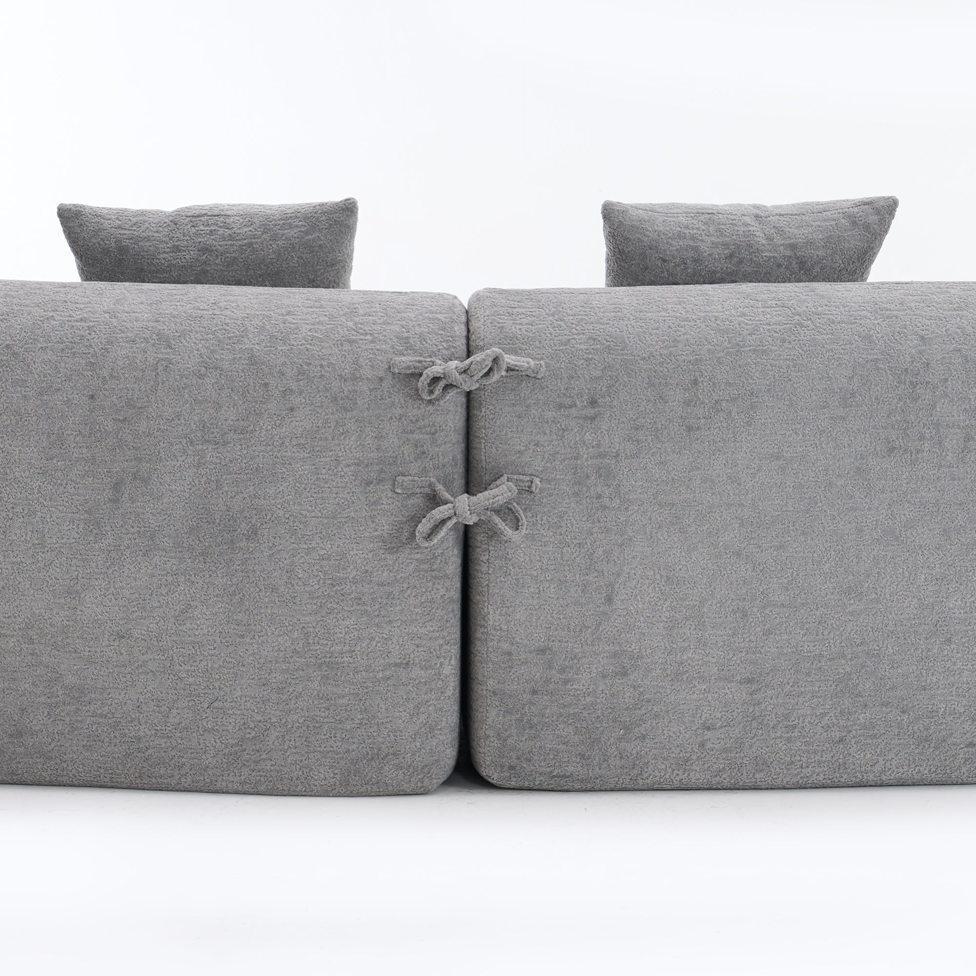 Close-up of the fabric connector ties on THE ORVILLE modular sectional, showing how the individual mist grey units securely attach to maintain the curved shape.