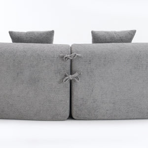 Close-up of the fabric connector ties on THE ORVILLE modular sectional, showing how the individual mist grey units securely attach to maintain the curved shape.
