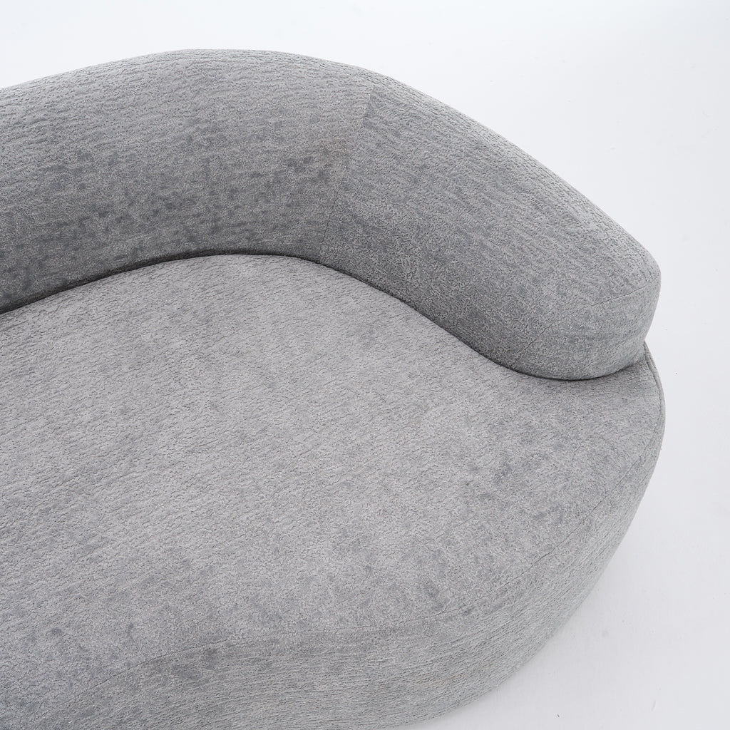 A side-angle view of the ORVILLE sofa’s curved backrest, showing the seamless Mist Grey chenille upholstery and soft, rounded architectural lines.