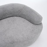 A side-angle view of the ORVILLE sofa’s curved backrest, showing the seamless Stone Grey chenille upholstery and soft, rounded architectural lines.