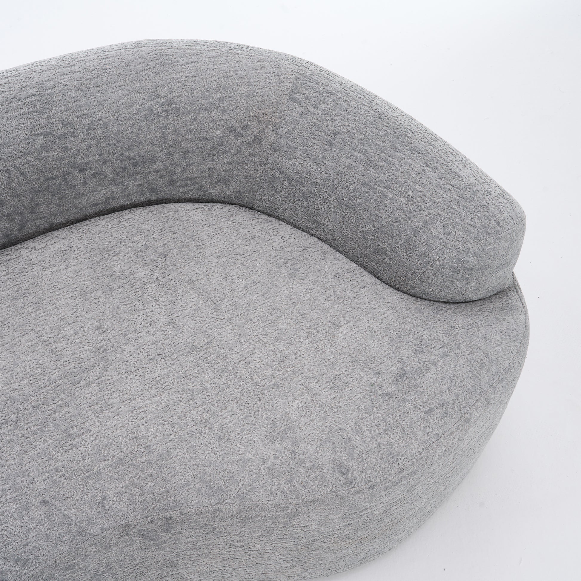 A side-angle view of the ORVILLE sofa’s curved backrest, showing the seamless Mist Grey chenille upholstery and soft, rounded architectural lines.