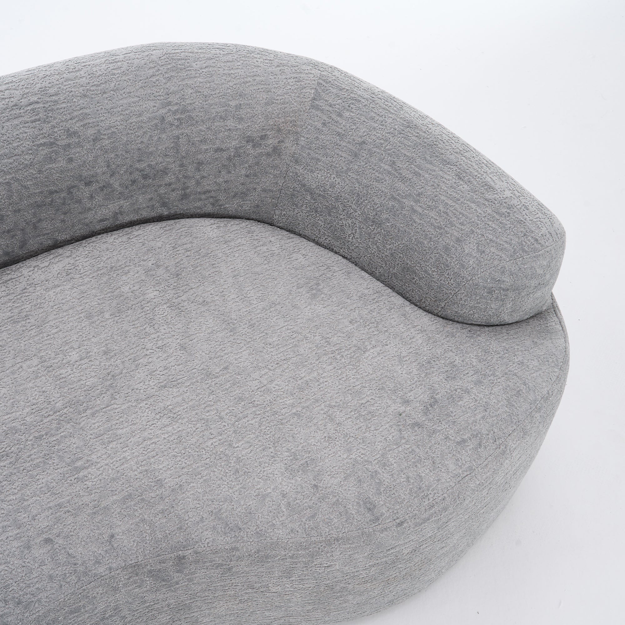 A side-angle view of the ORVILLE sofa’s curved backrest, showing the seamless Mist Grey chenille upholstery and soft, rounded architectural lines.