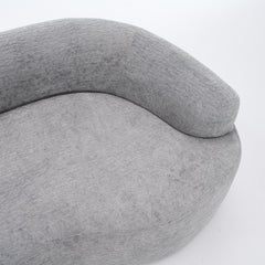 A side-angle view of the ORVILLE sofa’s curved backrest, showing the seamless Stone Grey chenille upholstery and soft, rounded architectural lines.