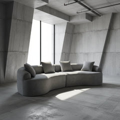 THE ORVILLE 110-inch curved modular sectional sofa in Stone Grey chenille fabric, featuring a modern low-profile all-foam design with rounded edges. Gray sectional sofa with cushions on a white background